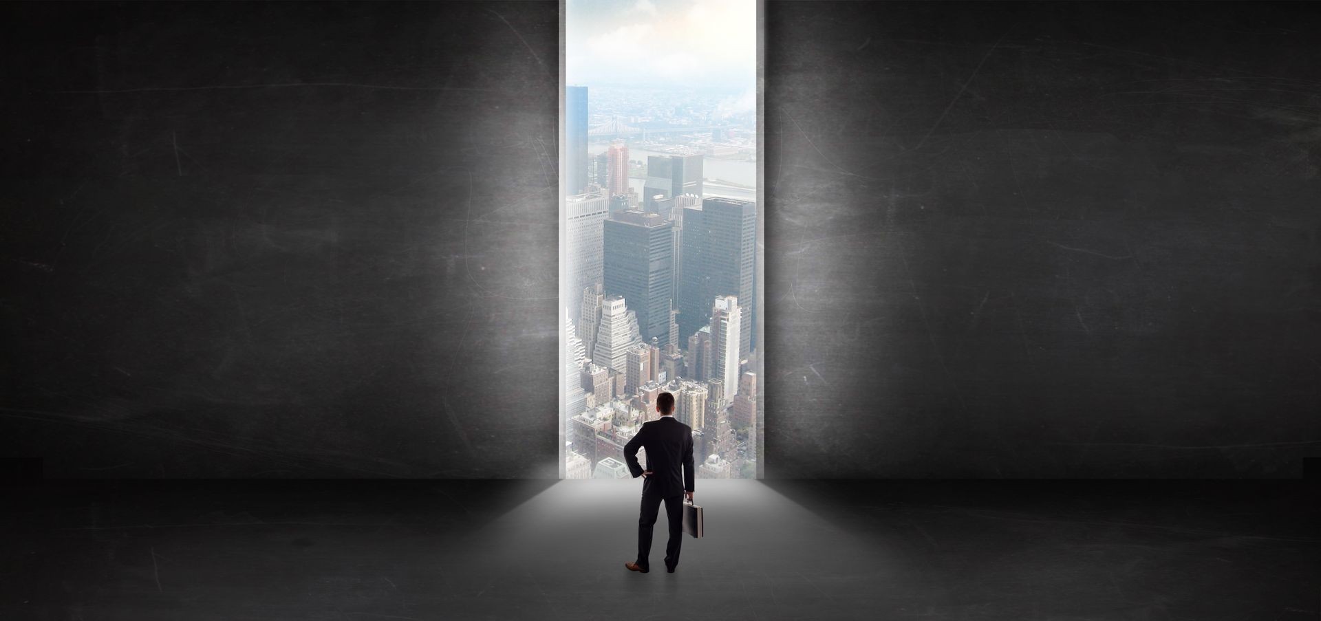 Businessman standing in a dark room and looking outside to a cityscape view Businessman standing in a dark room and looking outside to a cityscape view